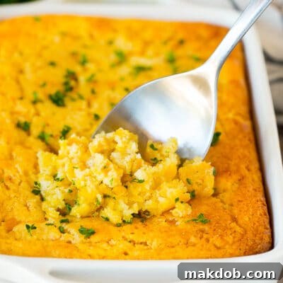 Cornbread casserole with a serving spoon in it.