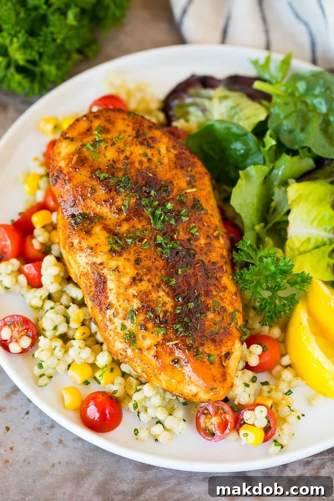 This air fryer chicken breast recipe consists of chicken coated in herbs and spices, then cooked to golden brown perfection. Air fryer chicken breast served with couscous and salad.