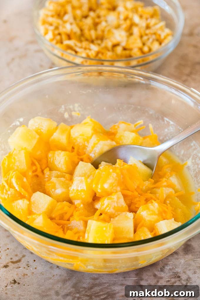 A bowl of pineapple chunks mixed with cheddar cheese, flour and sugar.