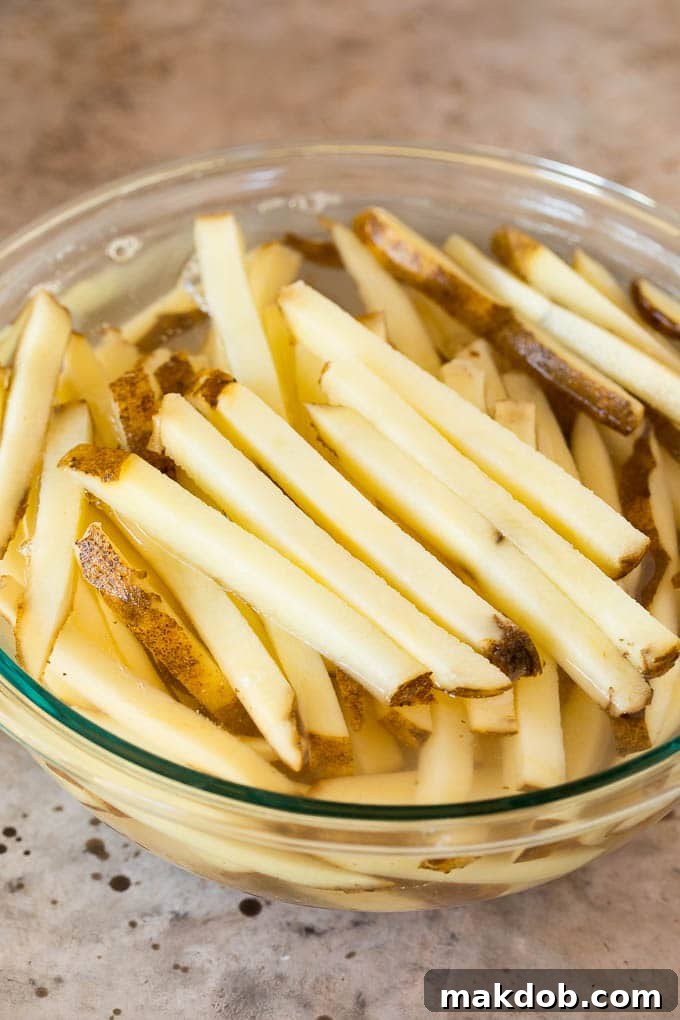 Cut potatoes in a bowl of water. Cut Russet potato sticks soaking in a bowl of cold water.