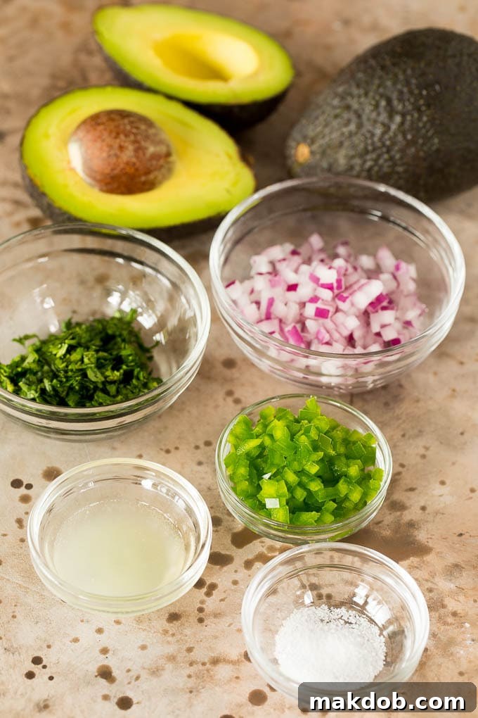 Copycat Chipotle Guacamole 3 Bowls of perfectly prepped ingredients for Chipotle guacamole, including vibrant green lime juice, fresh cilantro, finely diced red onion, and neatly chopped jalapeño, all arranged and ready to be combined for a delicious homemade dip.
