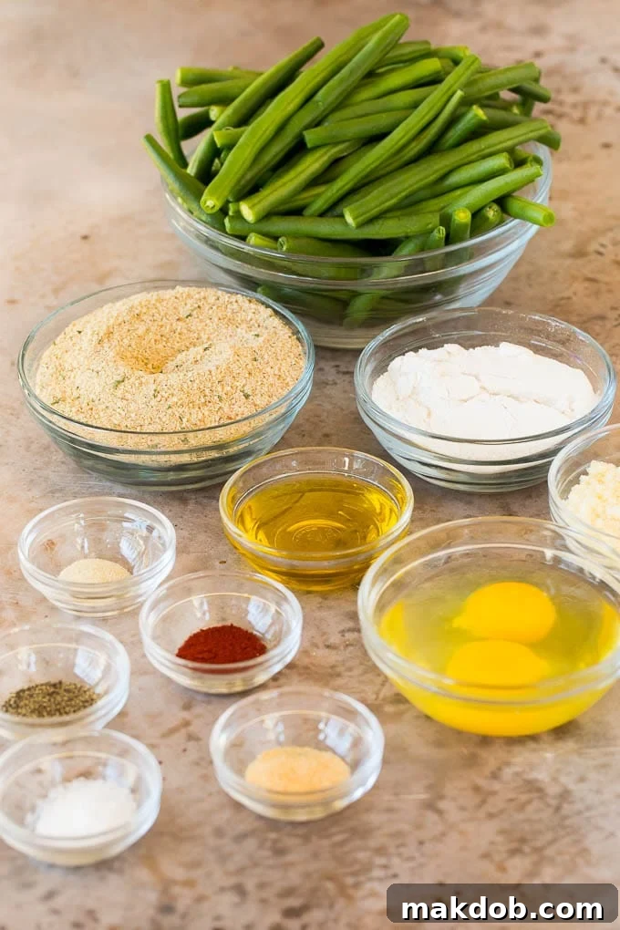 Bowls of green beans, breadcrumbs, flour, egg and seasonings.