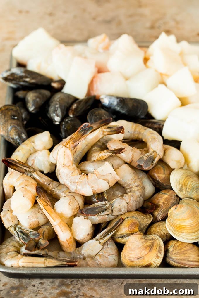 This bouillabaisse is French seafood stew with fresh fish, shrimp, clams and mussels, all simmered together in a flavorful broth. A pan of shrimp, clams, fish and mussels.