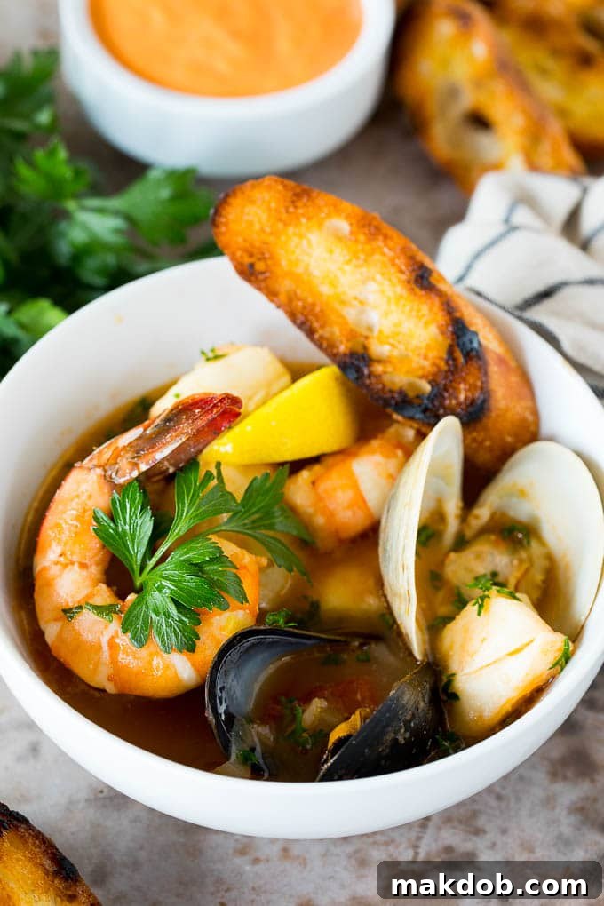 This bouillabaisse is French seafood stew with fresh fish, shrimp, clams and mussels, all simmered together in a flavorful broth. A bowl of bouillabaisse served with toasted bread slices.