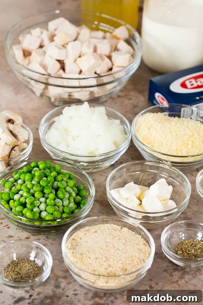 This turkey tetrazzini contains diced turkey, mushrooms and peas, all tossed with pasta in a creamy sauce, then baked to perfection. Bowls of diced meat, vegetables, seasonings and breadcrumbs, ready for making turkey tetrazzini.