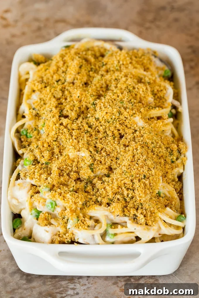 This turkey tetrazzini contains diced turkey, mushrooms and peas, all tossed with pasta in a creamy sauce, then baked to perfection. A casserole dish of creamy spaghetti with breadcrumbs on top, fresh out of the oven.
