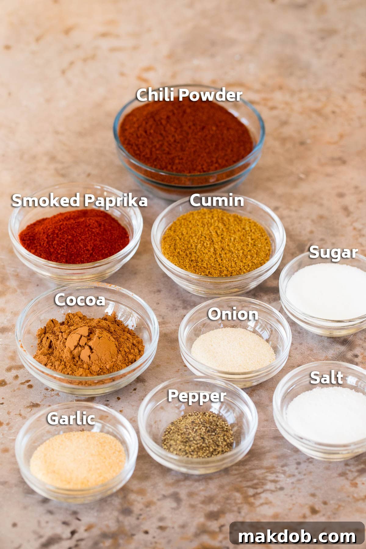 Glass bowls of different types of spices, ingredients for chili seasoning.