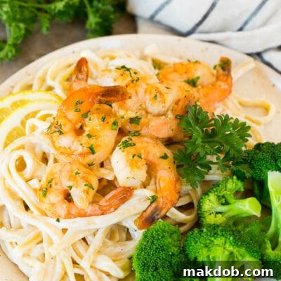 A plate of shrimp linguine served with broccoli.