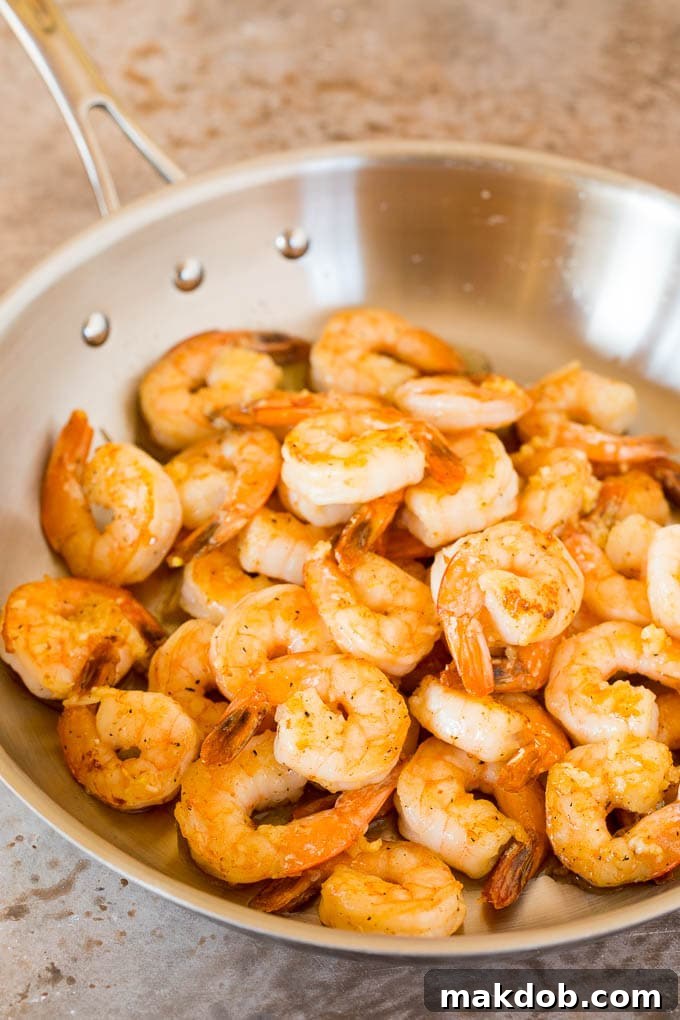 Cooked shrimp in a metal pan.