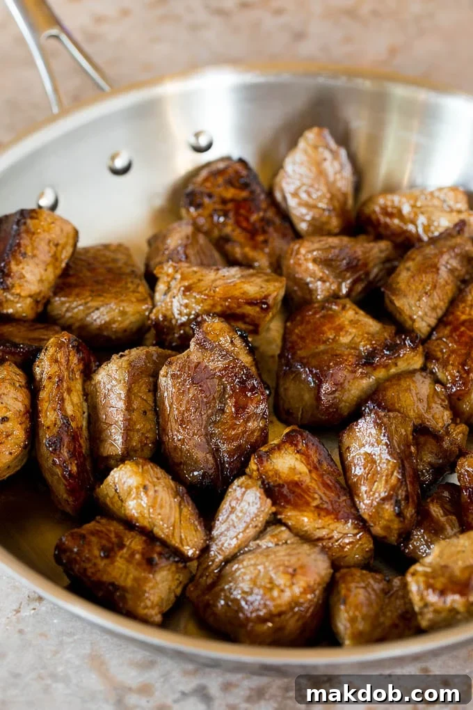 This slow cooker beef bourguignon is tender beef chunks, bacon, mushrooms, carrots and pearl onions, all simmered together in a rich red wine broth. Browned beef cubes in a skillet.