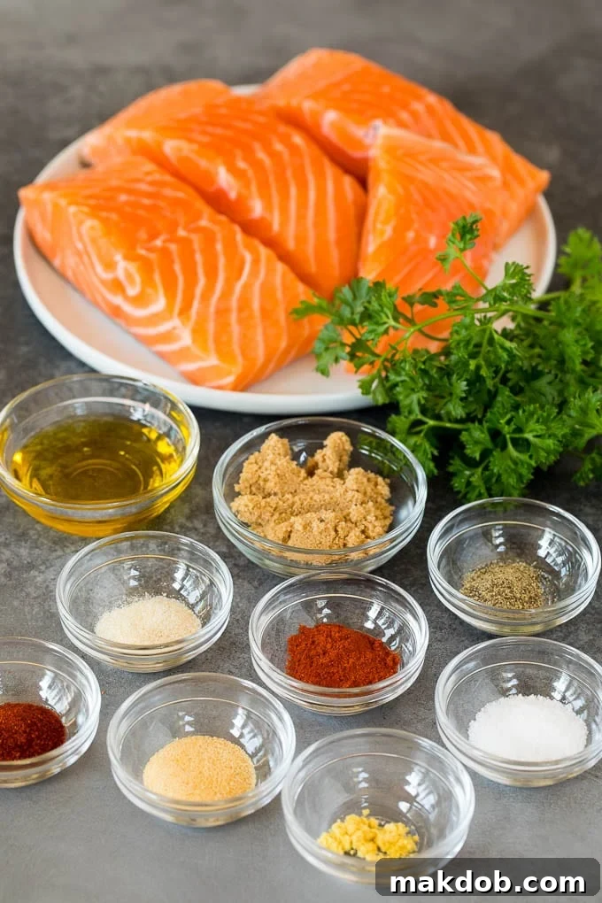 This air fryer salmon is fresh fish fillets topped with a homemade spice rub, then cooked to golden brown perfection. Salmon fillets and bowls of herbs, spices and olive oil.