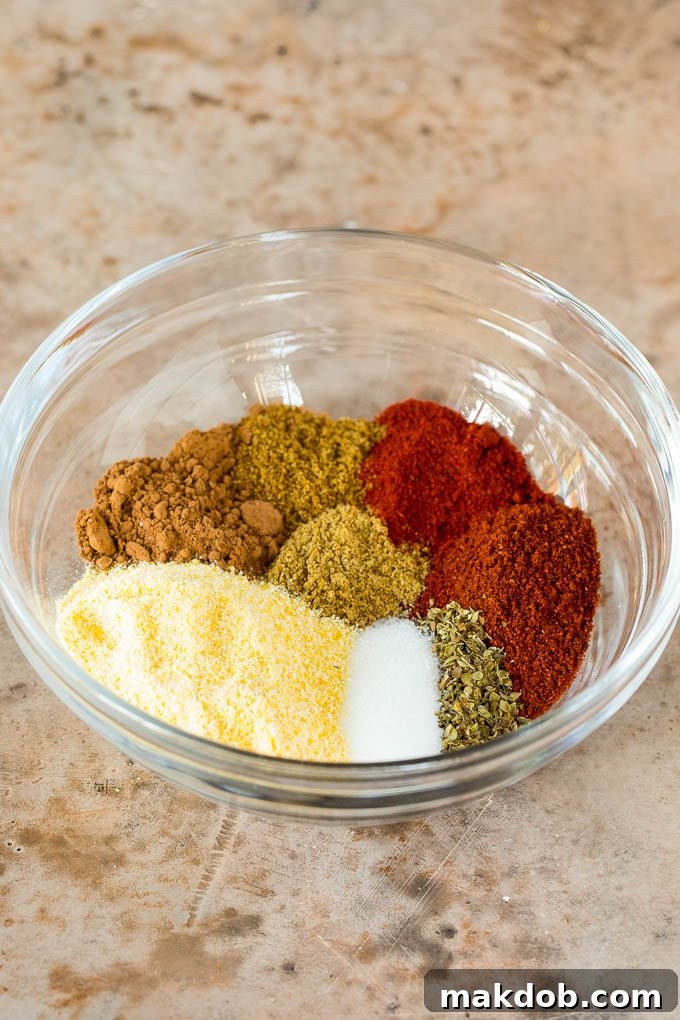 An array of meticulously measured spices, including chili powder, smoked paprika, cumin, and cocoa powder, arranged in small bowls, ready to be blended into the perfect Texas Chili spice mix.