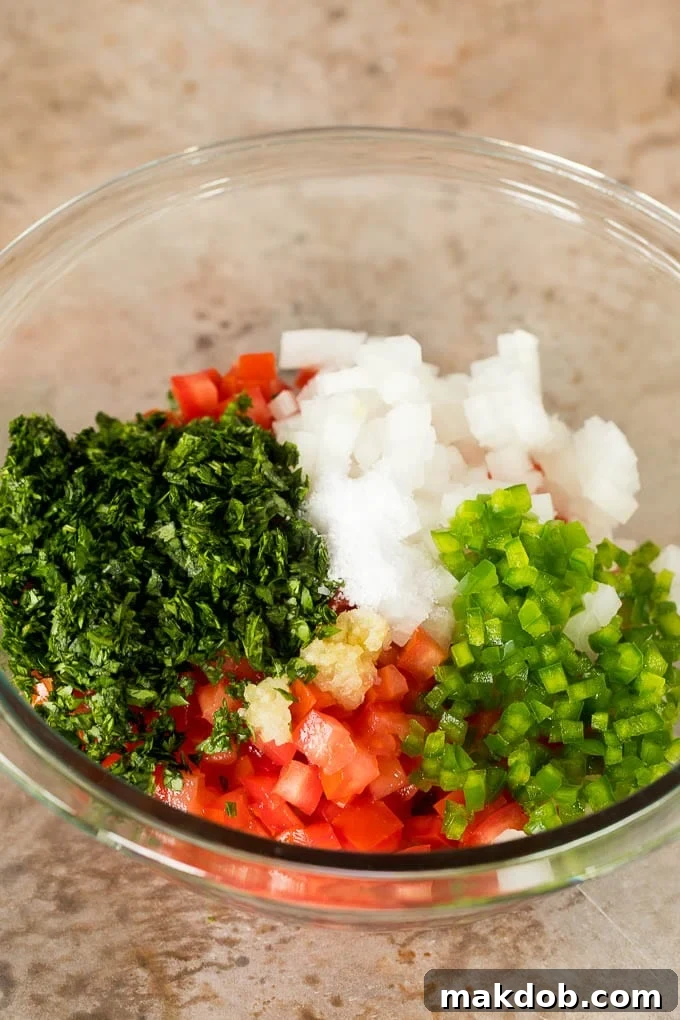 Classic Pico de Gallo Recipe 4 Diced tomatoes, vegetables and herbs in a bowl.