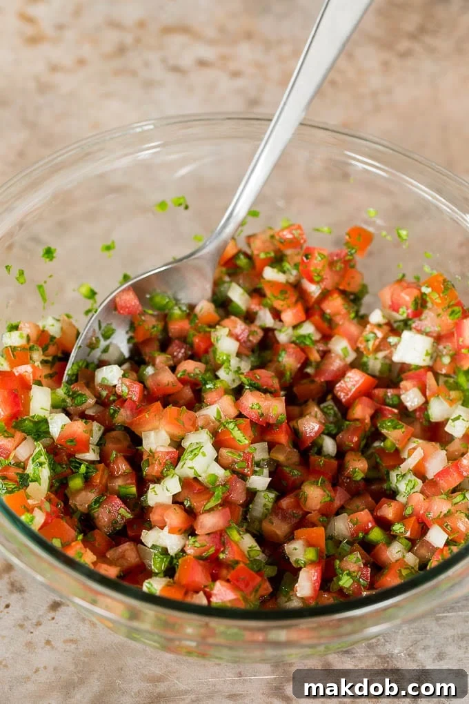 Classic Pico de Gallo Recipe 5 A bowl of tomatoes mixed with onions, peppers and cilantro.
