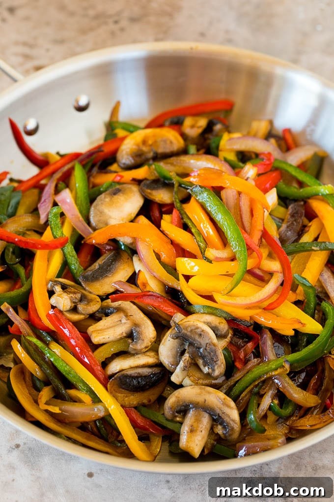 Plant-Powered Fajitas 4 A close-up shot of a hot pan filled with perfectly cooked peppers and mushrooms, showing their tender texture and slight char, ready to be seasoned.