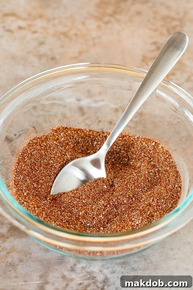 A small glass jar filled with homemade fajita seasoning, neatly labeled, sitting on a wooden surface, ready for storage.