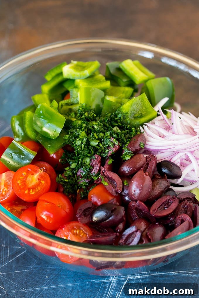 Fresh Mediterranean Salad 4 Cherry tomatoes, cucumbers, bell peppers and olives in a bowl, waiting to be dressed.