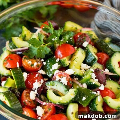 Mediterranean Sunshine Salad 7 A bowl of Mediterranean salad with tomatoes, cucumbers, peppers and olives, representing the final dish.