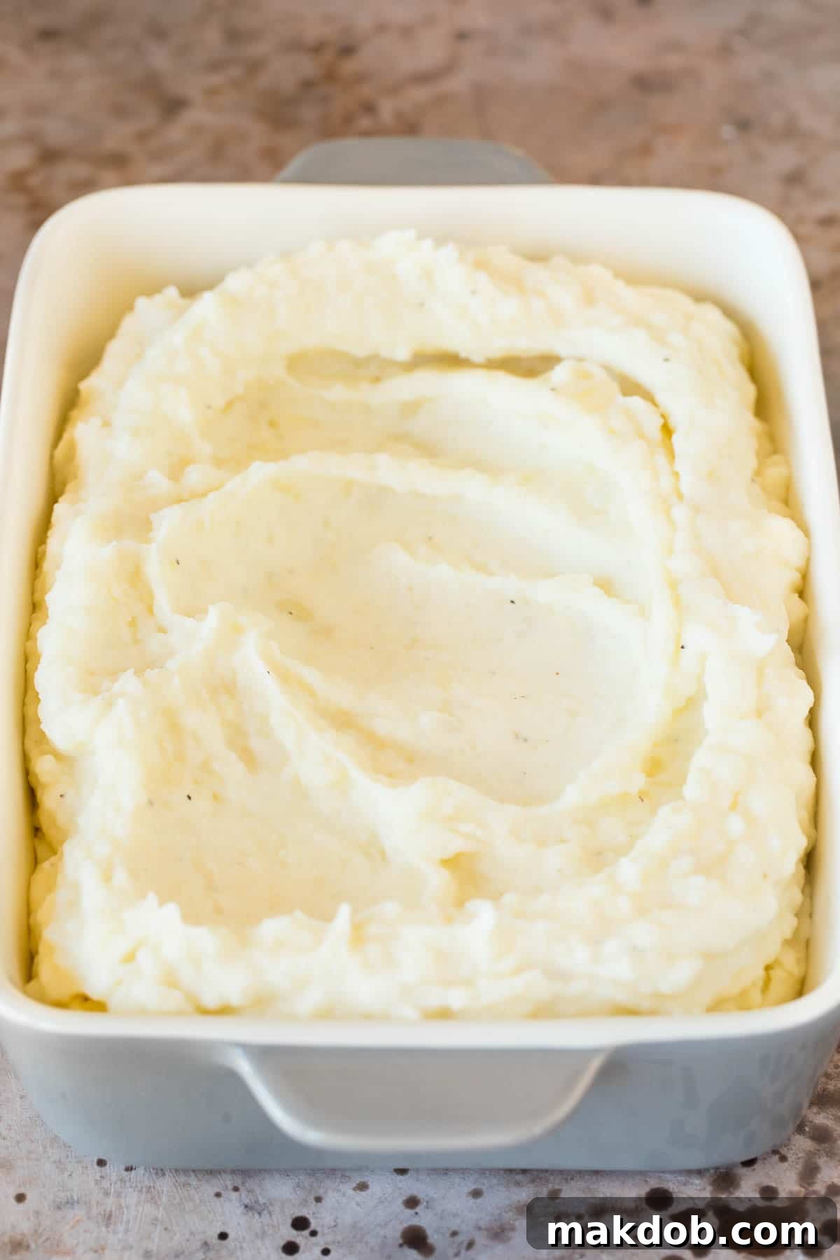 These make ahead mashed potatoes are Russet potatoes that are boiled until tender, then combined with butter, garlic, cream cheese and seasonings to make the ultimate side dish. Perfectly mashed potatoes spread in a baking dish, ready for reheating or serving.