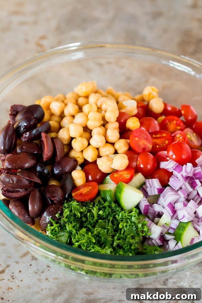 Vibrant Mediterranean Couscous Salad 5 Olives, tomatoes, cucumber, onions and parsley in a bowl of couscous.