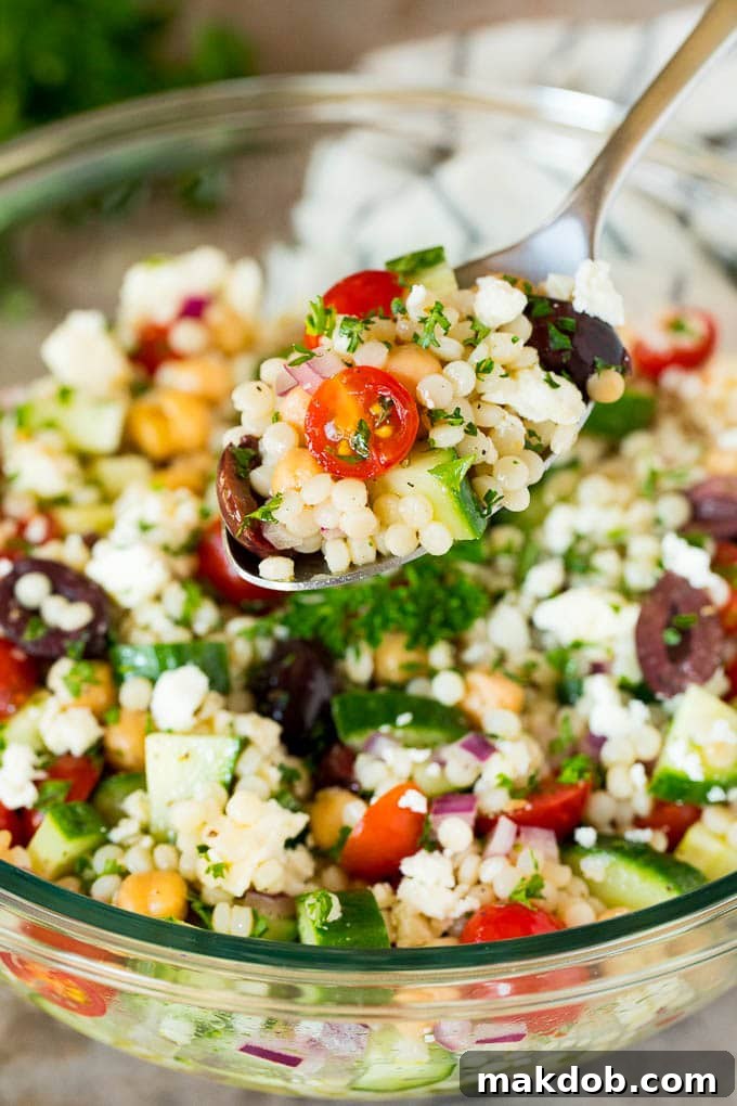 Vibrant Mediterranean Couscous Salad 6 A spoon holding up a serving of couscous salad.