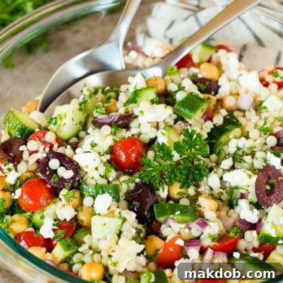 A bowl of couscous salad garnished with parsley.