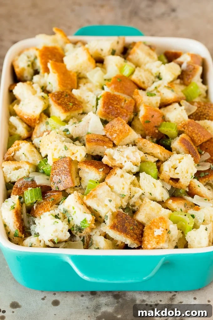 Uncooked Thanksgiving stuffing, moist and ready for the oven, nestled in a ceramic baking dish.