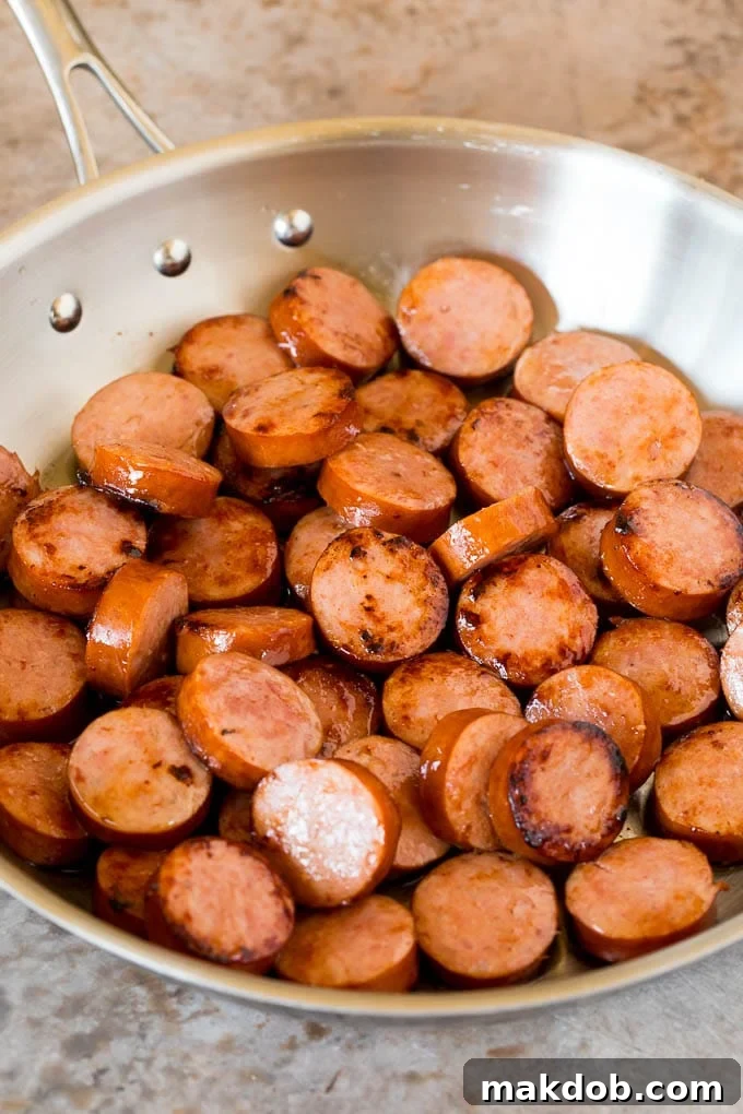This cabbage and sausage skillet is a combination of smoked sausage, vegetables and savory seasonings, all cooked together to make a quick and easy dinner. Sliced cooked kielbasa in a pan.