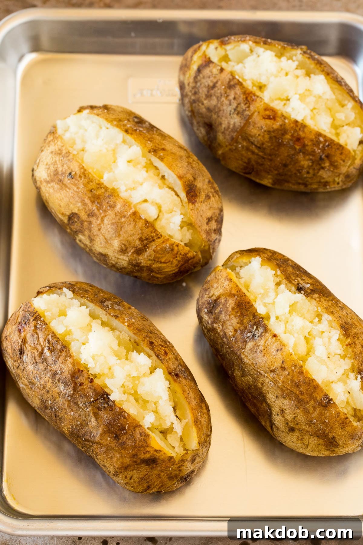 Perfectly Roasted Potatoes 5 Cooked potatoes split open on a sheet pan.