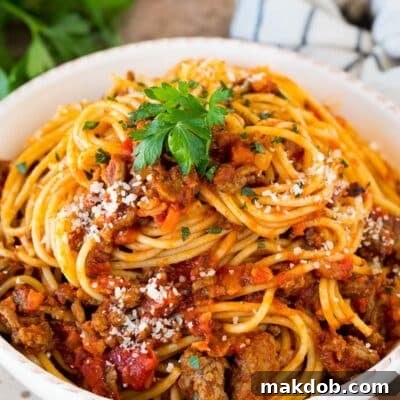Slow cooker bolognese sauce served with spaghetti.