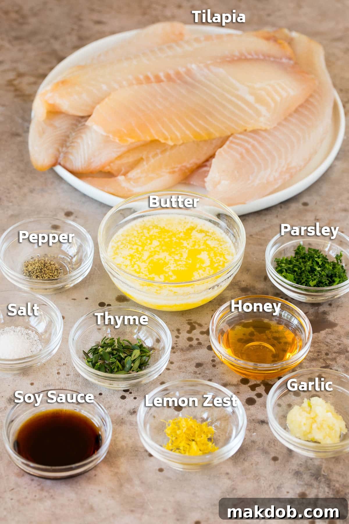 Savory Garlic Butter Tilapia Bake 3 Fresh tilapia fillets with bowls of sauce ingredients including butter, lemon and herbs.