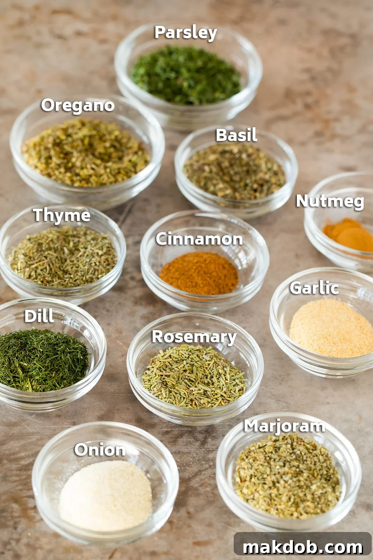 Bowls of various dried herbs and spices, meticulously arranged for Greek seasoning.