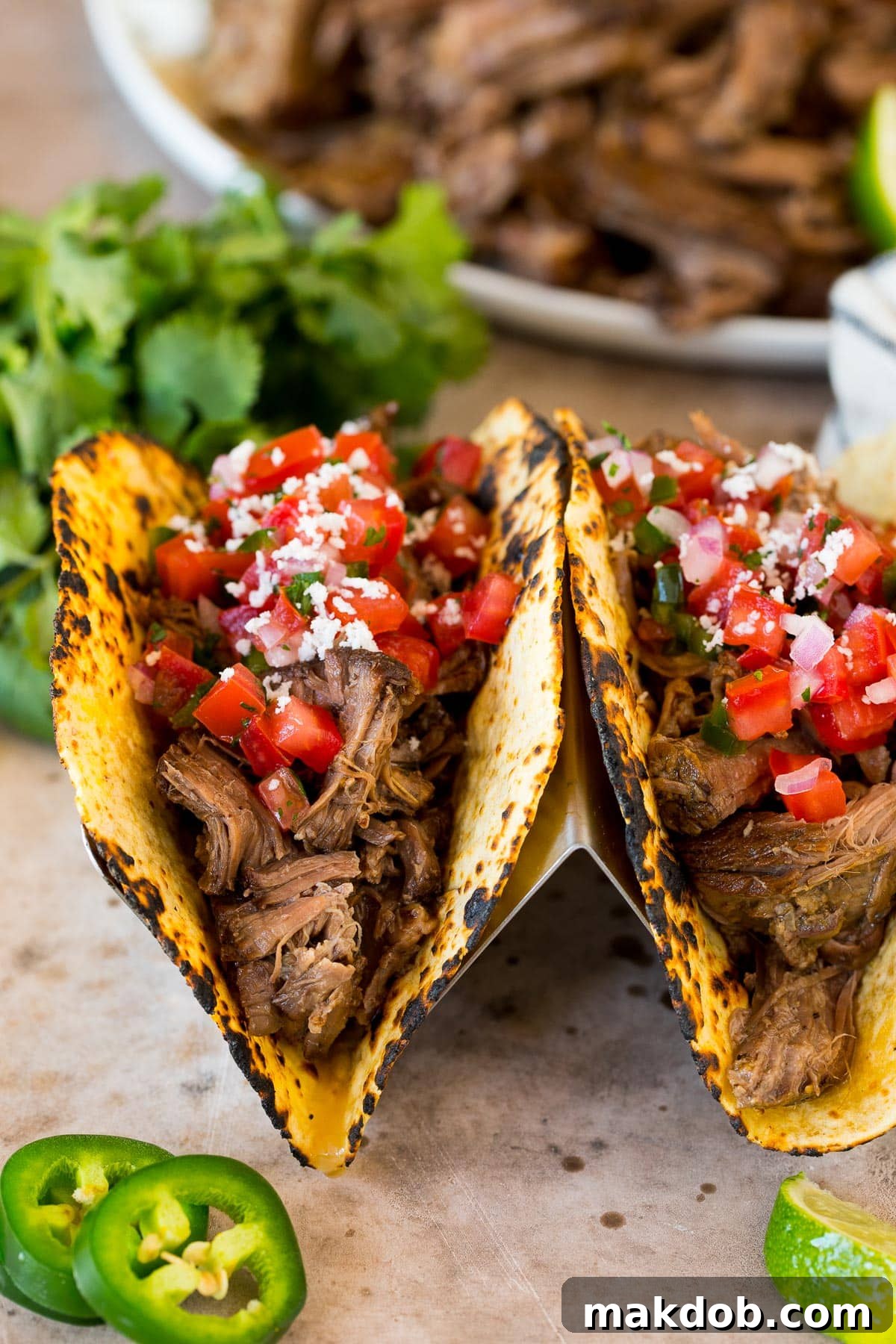 Chipotle barbacoa tacos topped with fresh salsa, cotija cheese, and cilantro.