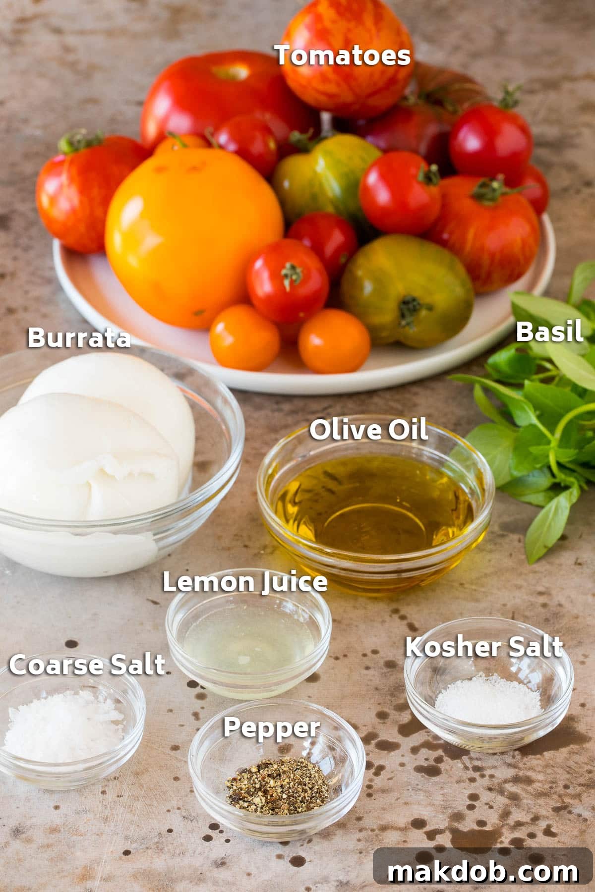 Bowls of fresh ingredients including vibrant tomatoes, high-quality olive oil, a ball of burrata cheese, and seasonings, ready for assembly.