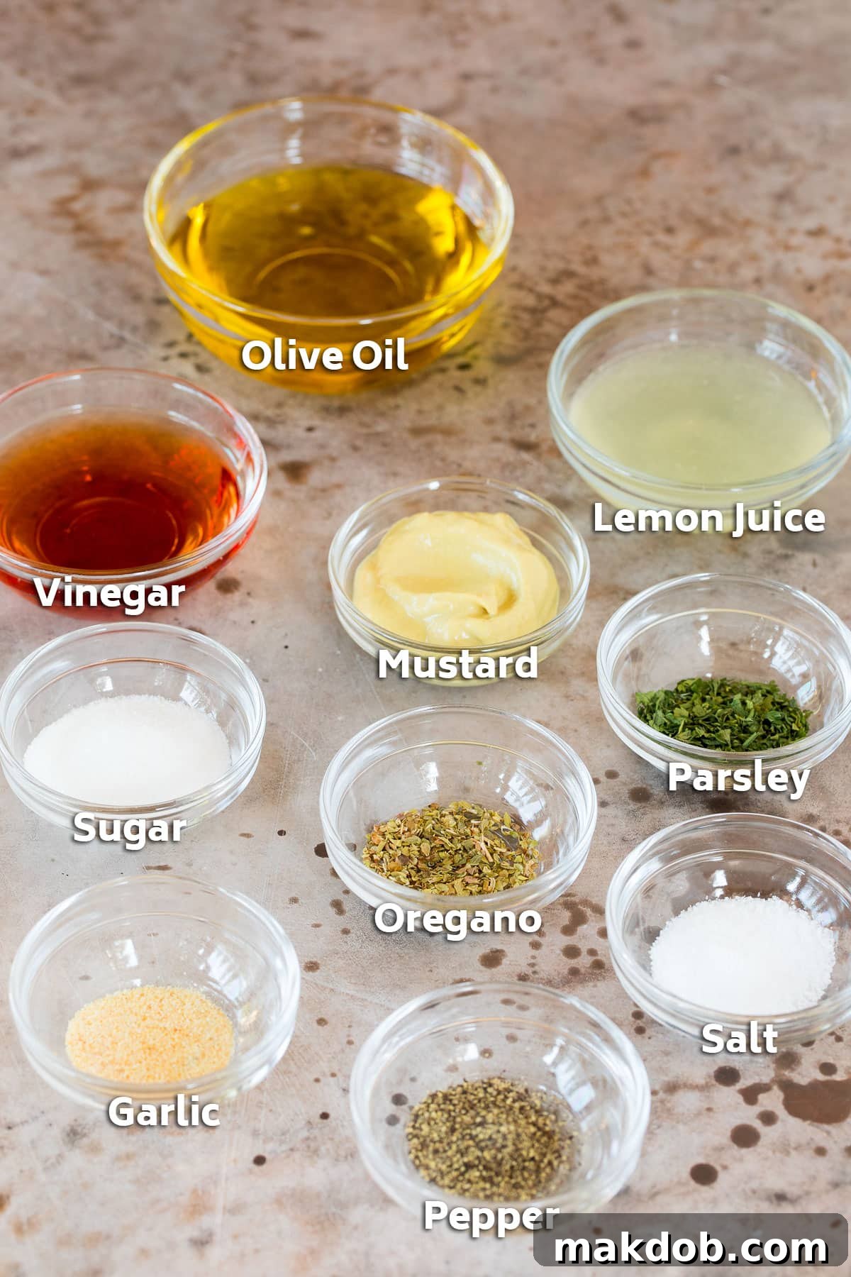 Small bowls of ingredients laid out to make a homemade salad dressing, including olive oil, lemon, and spices.