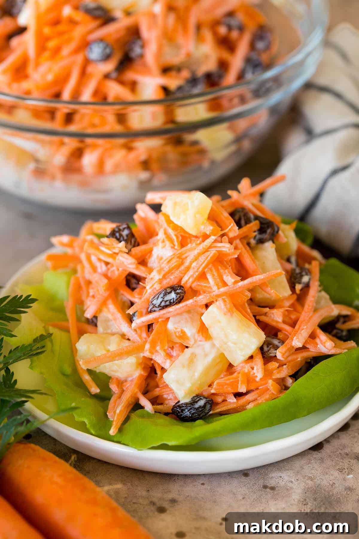 A perfectly portioned serving of creamy carrot salad, elegantly presented on a crisp lettuce leaf.