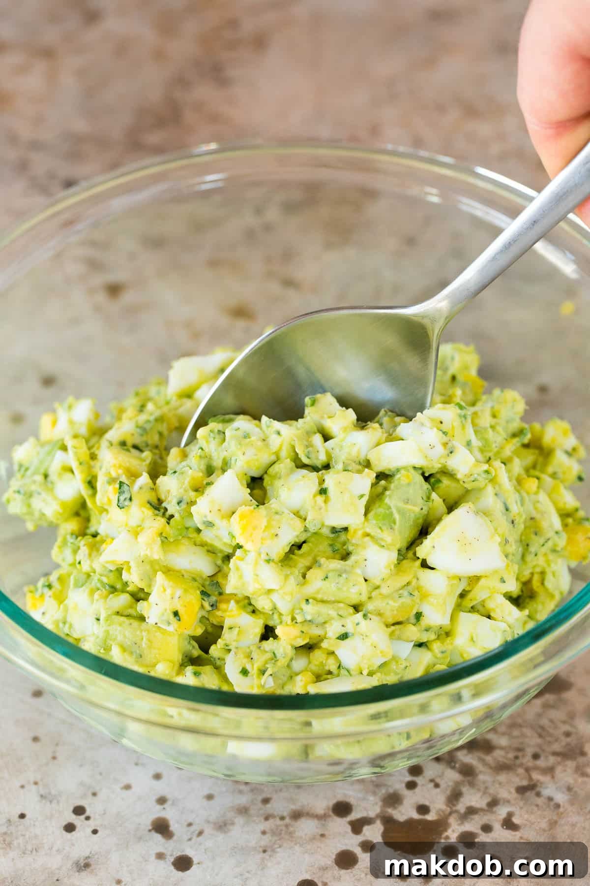Eggs in a bowl with an avocado mayonnaise mixture.