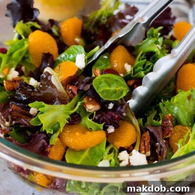 Sunshine Mandarin Salad 7 Tongs in a bowl of mandarin orange salad.