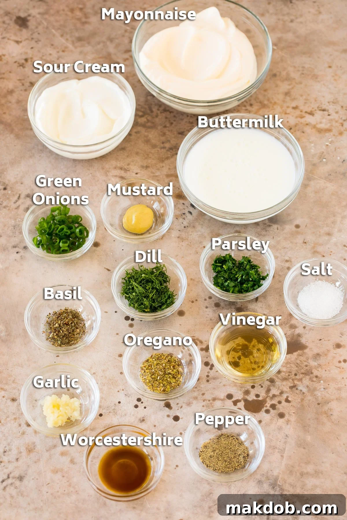 Bowls of ingredients including creamy mayonnaise, rich sour cream, tangy buttermilk, and a vibrant mix of fresh herbs for ranch dressing.
