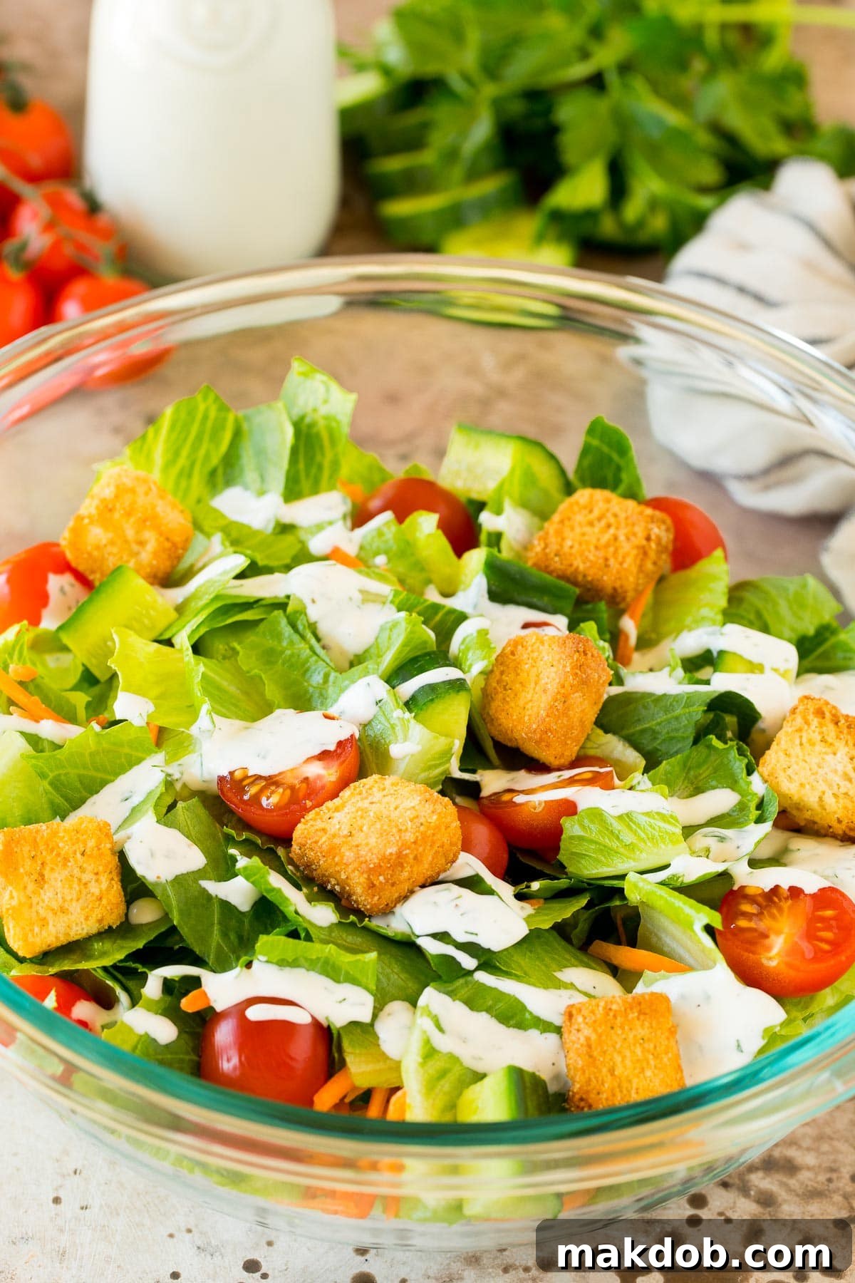 A vibrant green salad generously drizzled with rich, creamy homemade ranch dressing.