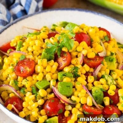 Avocado corn salad in a serving bowl topped with cilantro.