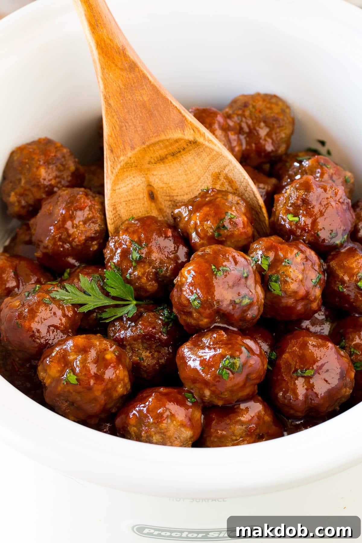 Sticky Grape Glazed Meatballs 6 A slow cooker filled with grape jelly meatballs, with a serving spoon inside, ready to be served.