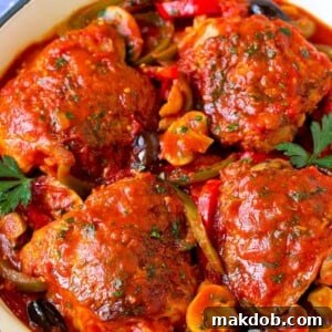 Rustic chicken cacciatore, featuring chicken thighs, colorful peppers, olives, and mushrooms simmered in a rich tomato sauce.