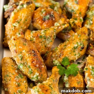 A pan of garlic parmesan wings garnished with parsley.