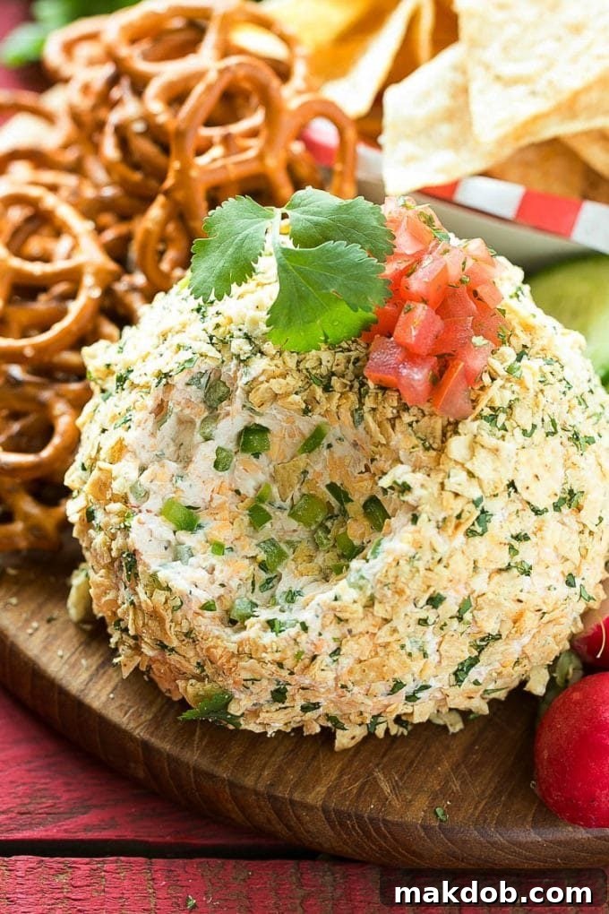A close-up of the creamy cheese ball filling, revealing pieces of fresh jalapenos and shredded cheddar cheese.