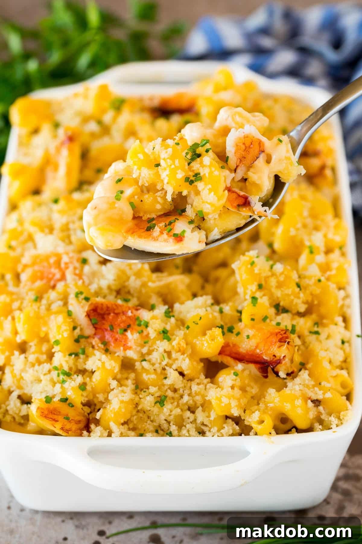 Decadent Crab Macaroni 4 A pan of crab and cheese with a spoon holding up a portion.