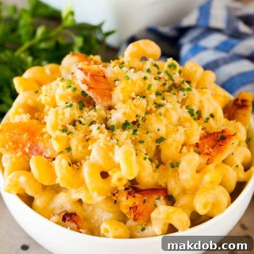 A bowl of crab mac and cheese topped with herbs.
