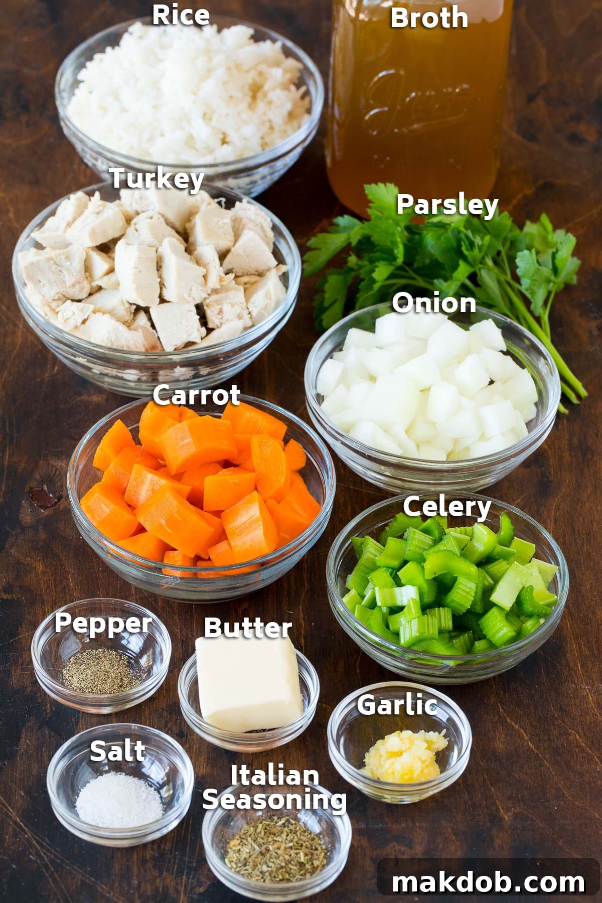 Bowls of prepped ingredients for turkey and rice soup, including diced turkey, chopped vegetables, fresh herbs, and various spices.