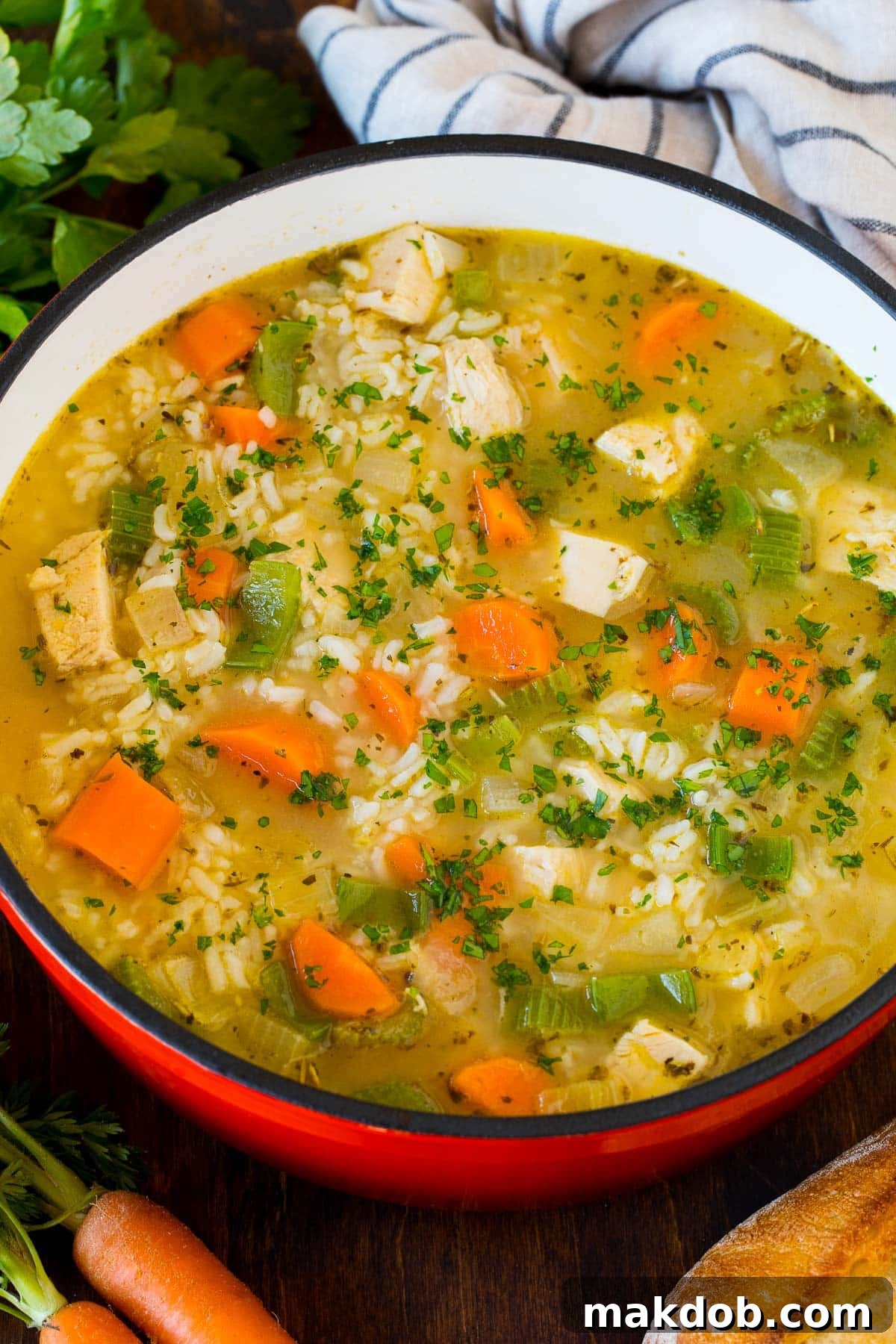 A generous pot of turkey and rice soup, beautifully topped with a sprinkle of fresh green parsley, ready to be served.
