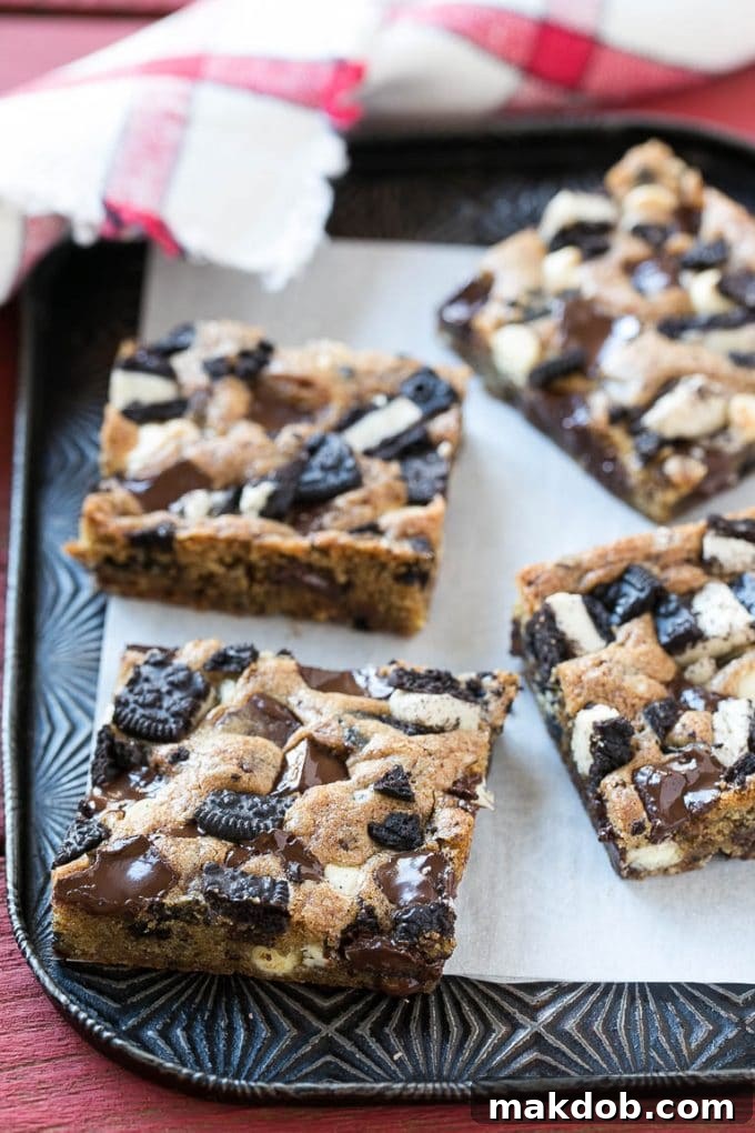 Freshly baked cookies and cream blondies cooling on a sheet pan, ready to be cut into delicious squares.